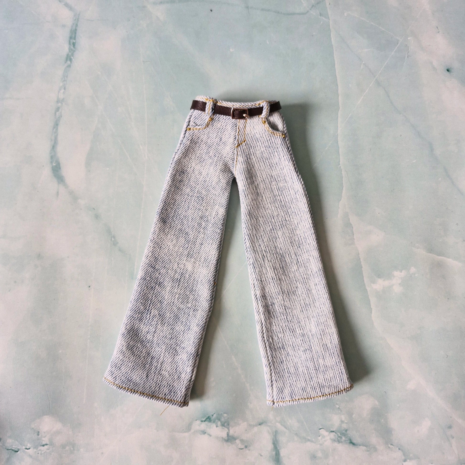 Striped pants with a belt on a textured gray surface