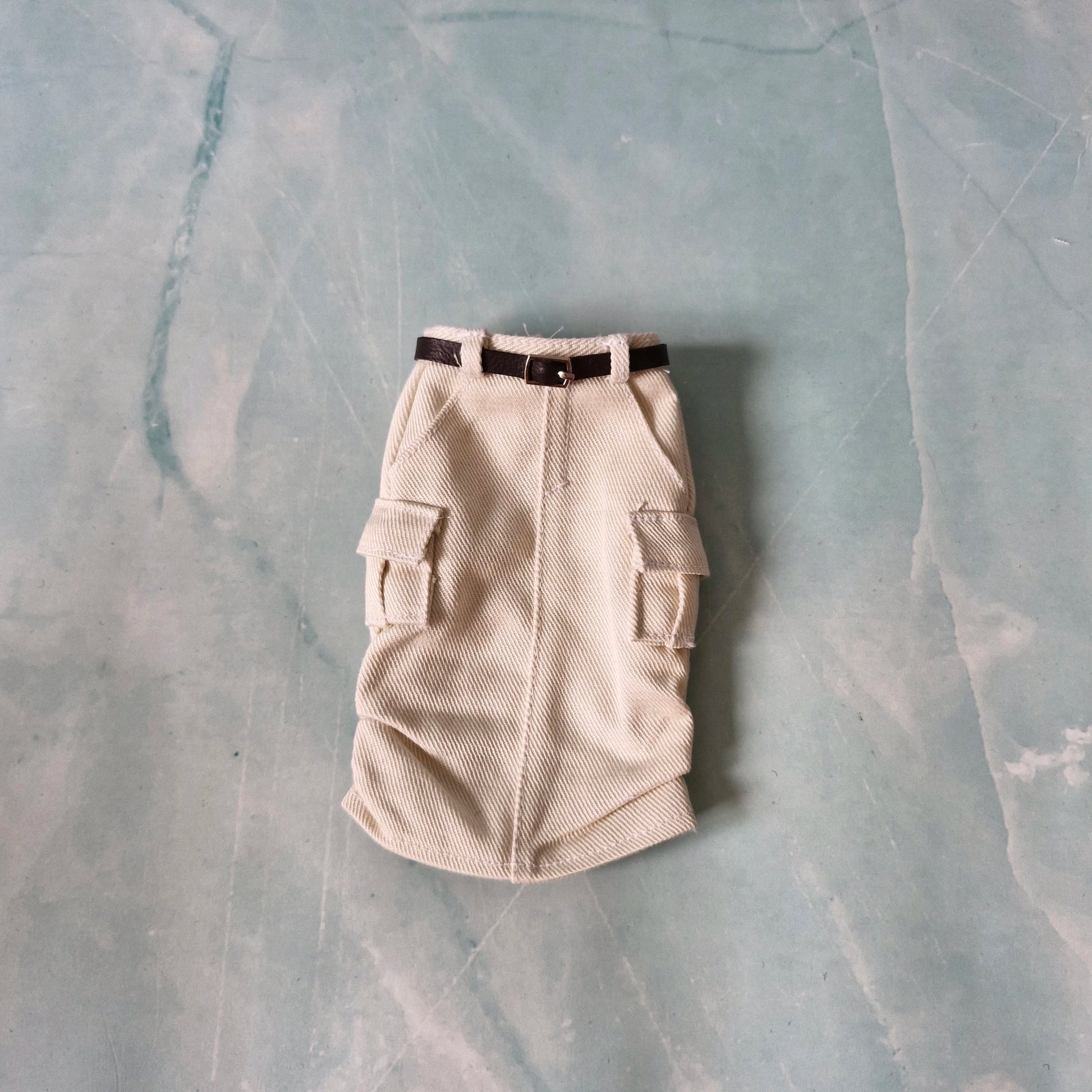 Beige cargo-style dog coat on a textured gray surface