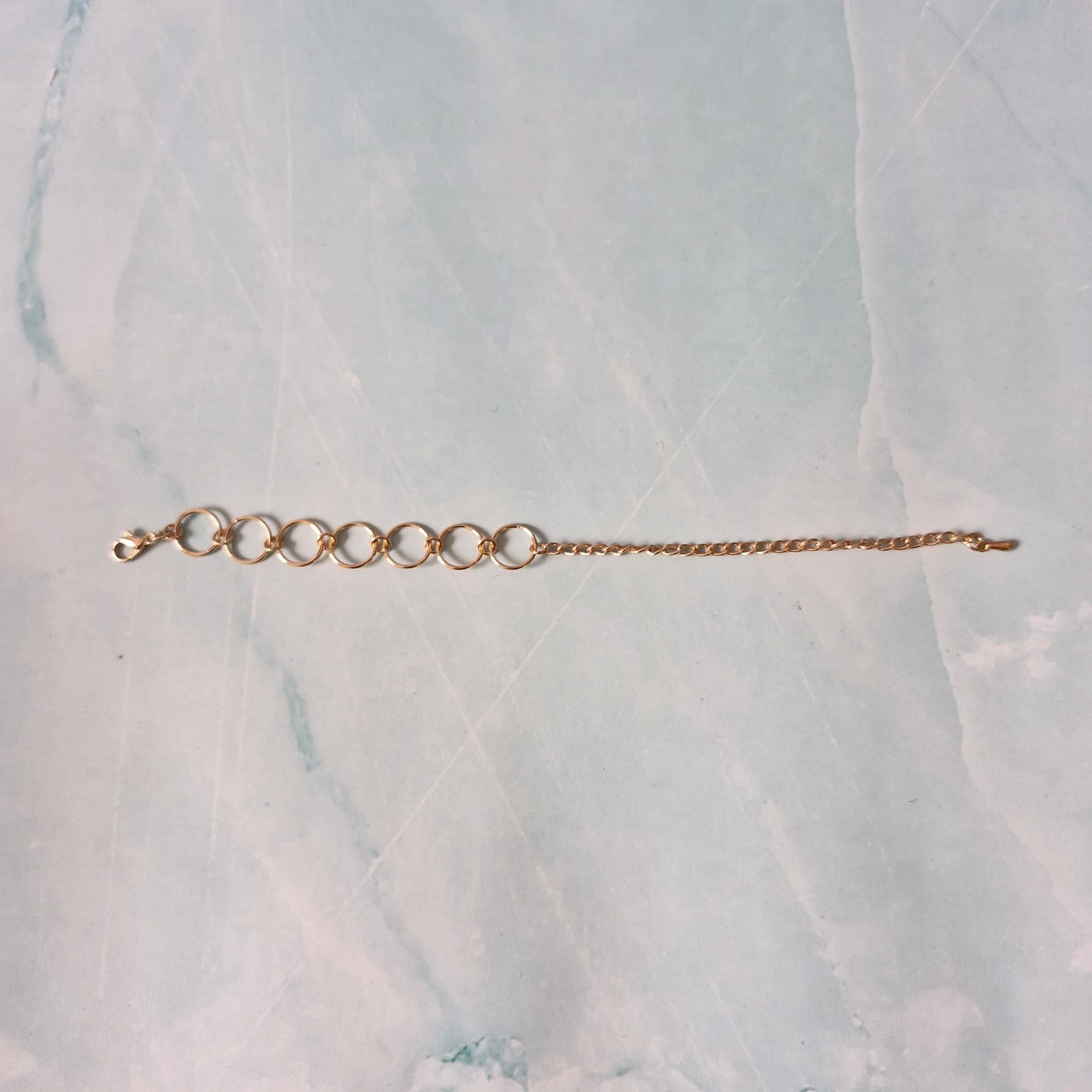 Gold bracelet on a marble surface