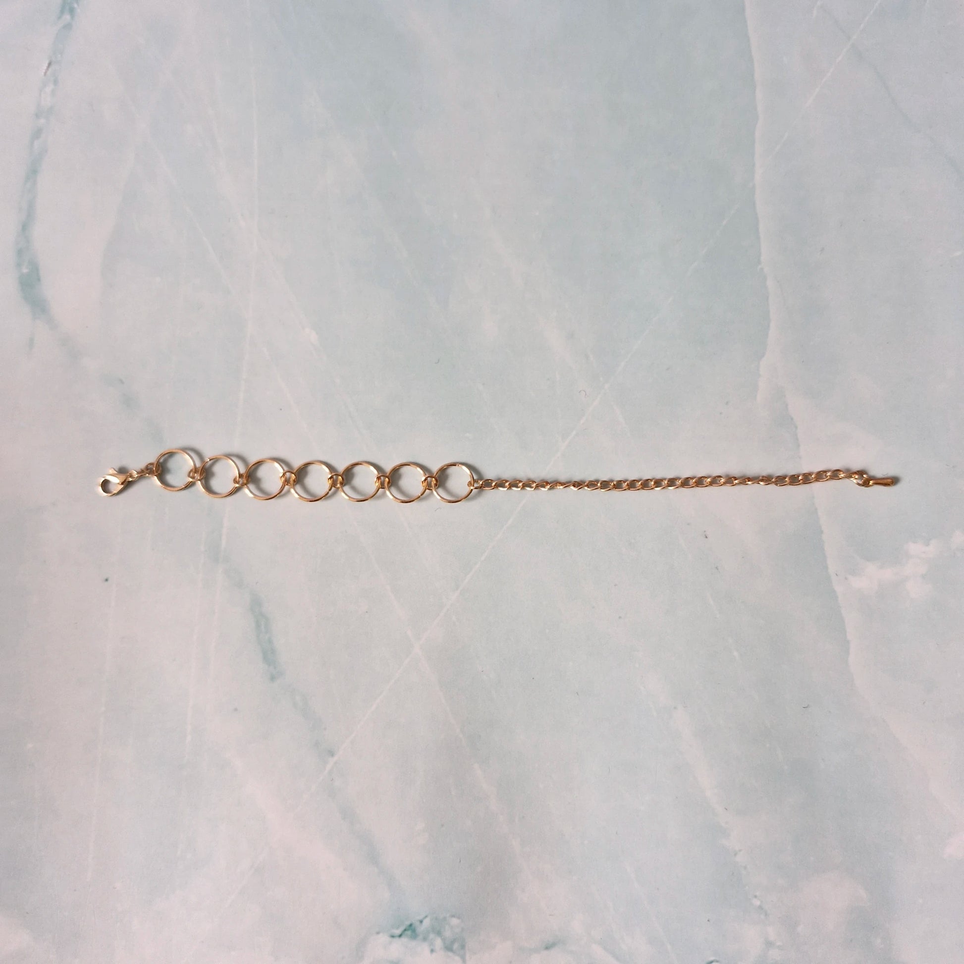 Gold bracelet on a marble surface